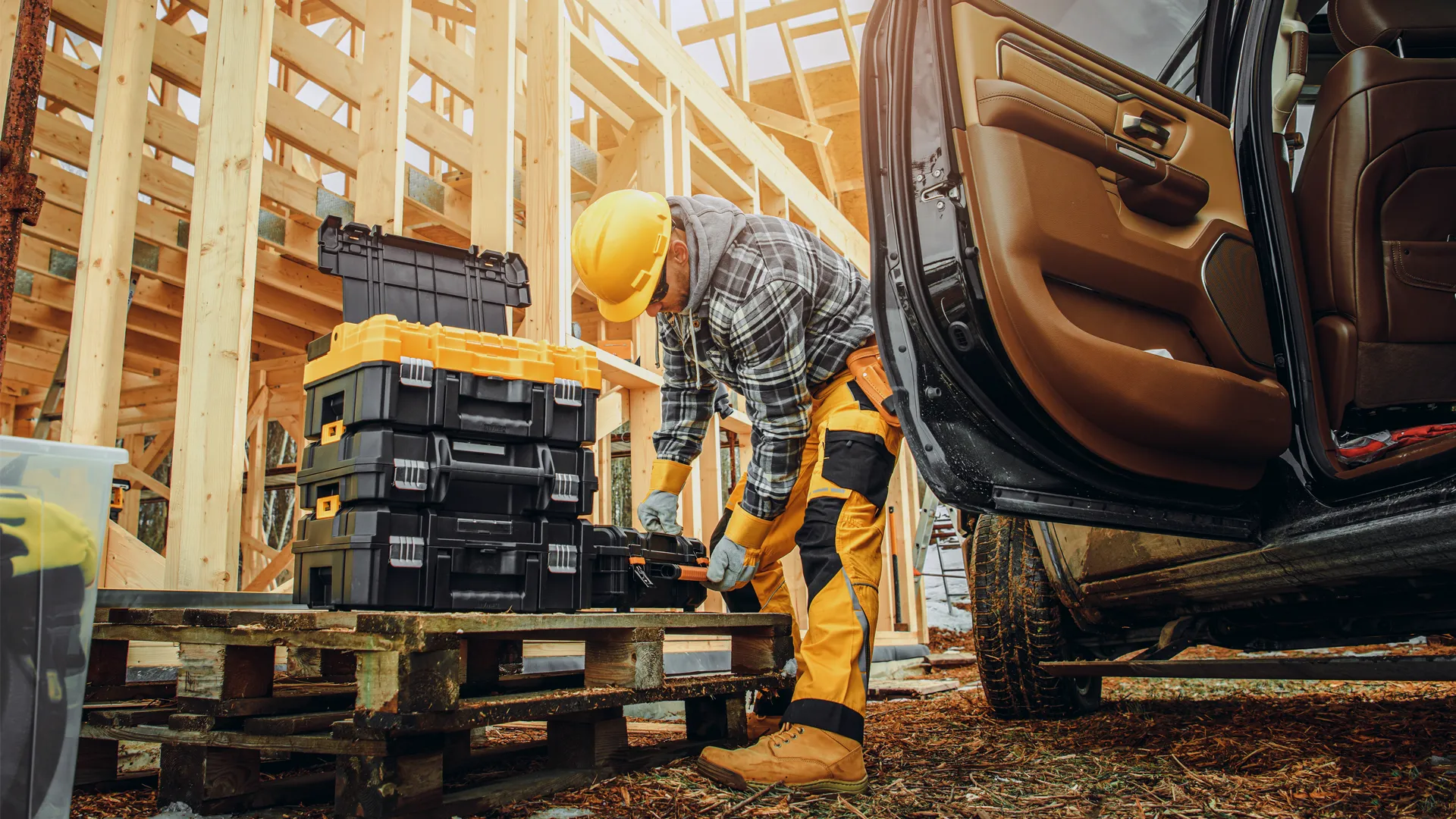 Construction worker unloading tools from van at site